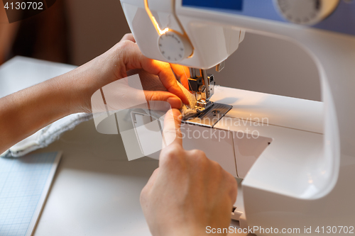 Image of Seamstress sews fabric on machine