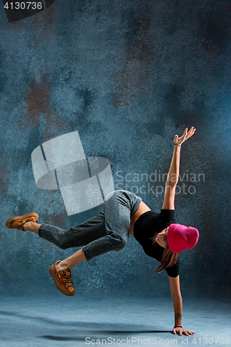 Image of Young girl break dancing on wall background.