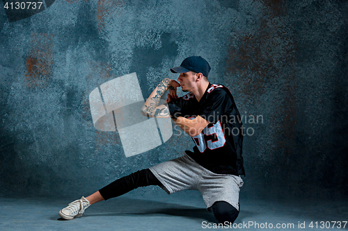 Image of Young man break dancing on wall background.