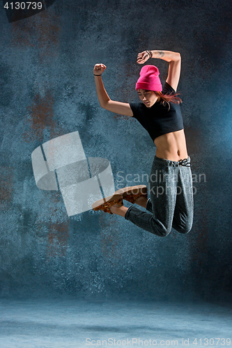 Image of Young girl break dancing on wall background.