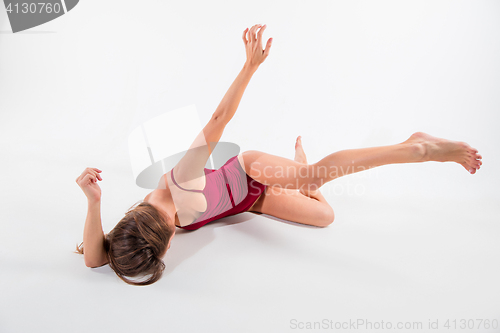 Image of Young beautiful dancer in beige dress dancing on white background