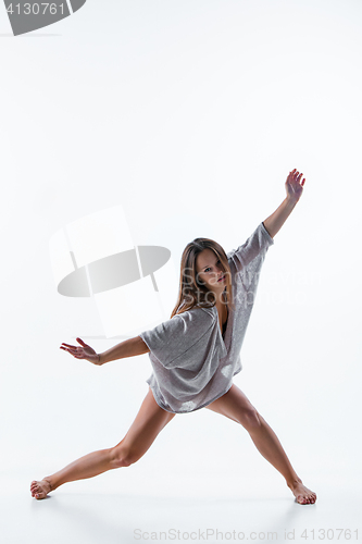 Image of Young beautiful dancer in beige dress dancing on white background