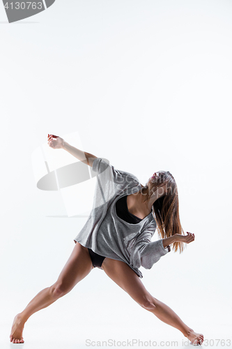 Image of Young beautiful dancer in beige dress dancing on white background