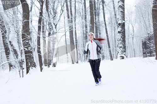 Image of Young sportswoman running in morning