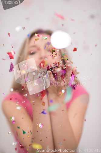 Image of woman blowing confetti in the air