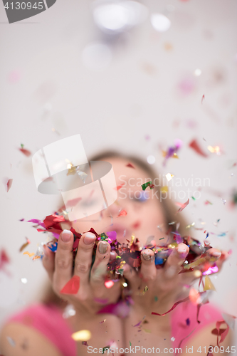 Image of woman blowing confetti in the air