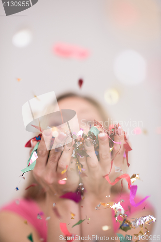 Image of woman blowing confetti in the air