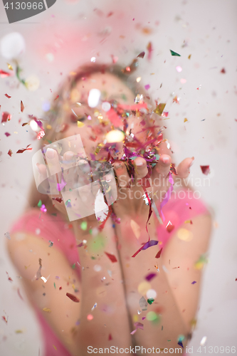 Image of woman blowing confetti in the air