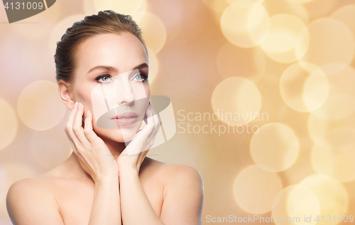 Image of beautiful young woman touching her face