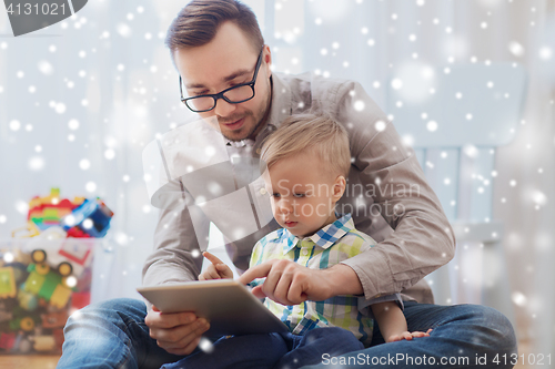 Image of father and son with tablet pc playing at home