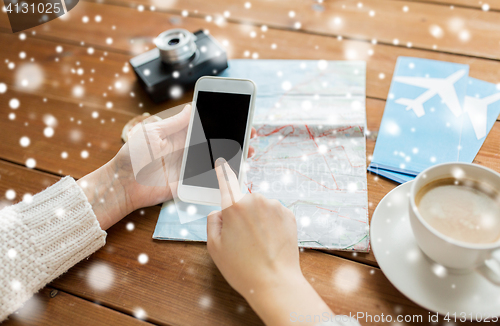 Image of close up of traveler hands with smartphone and map