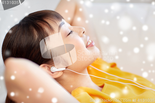 Image of happy asian woman with earphones listening music