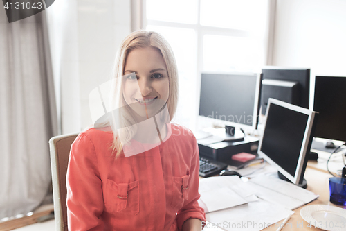 Image of happy creative female office worker with computers