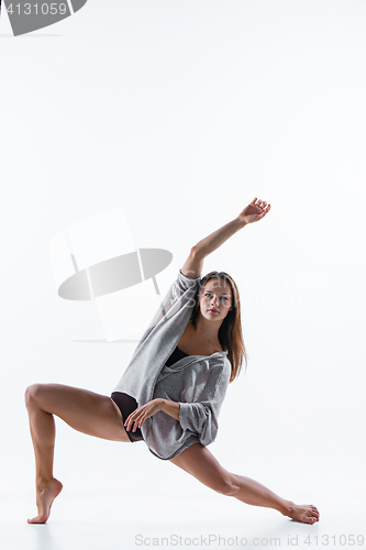 Image of Young beautiful dancer in beige dress dancing on white background