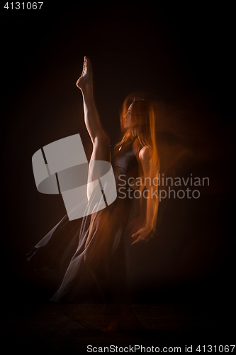 Image of Young beautiful dancer in beige dress dancing on black background