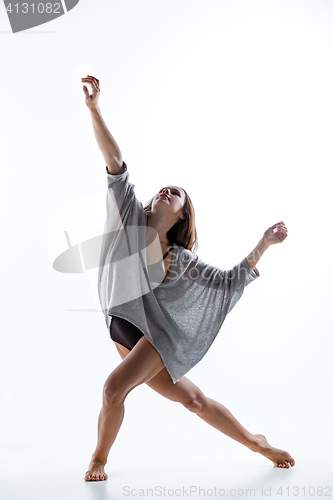 Image of Young beautiful dancer in beige dress dancing on white background