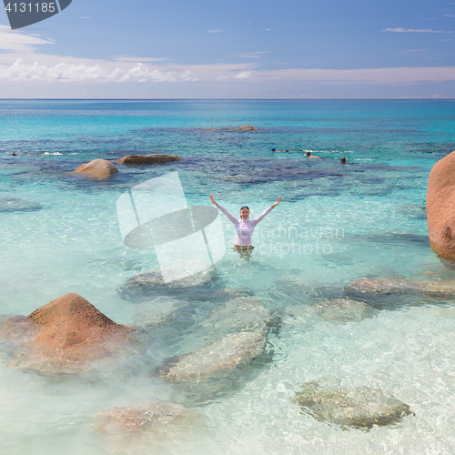 Image of Woman enjoying Anse Lazio picture perfect beach on Praslin Island, Seychelles.