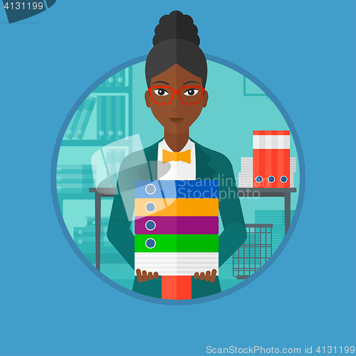 Image of Business woman holding pile of folders in office.