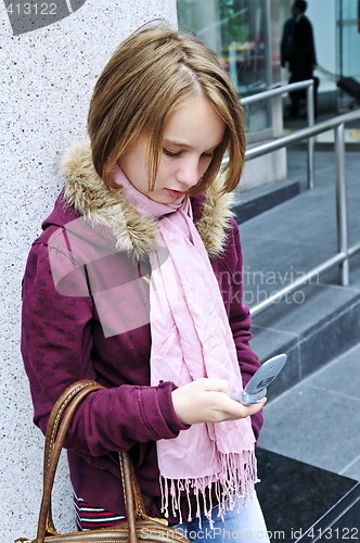 Image of Teenage girl text messaging on cell phone
