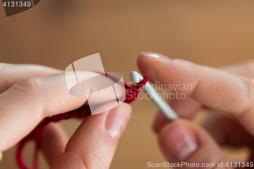 Image of close up of hands knitting with crochet hook