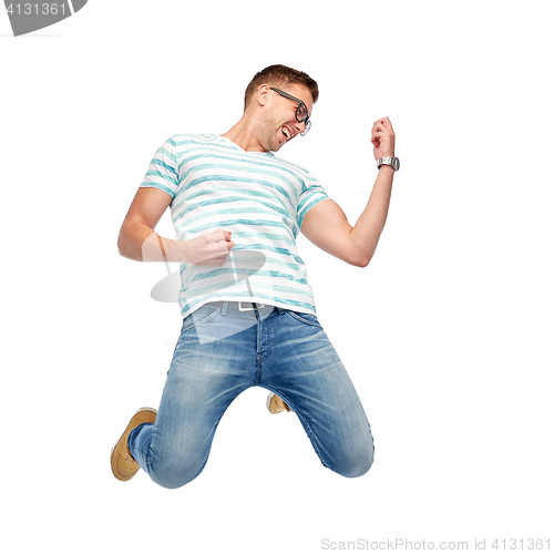 Image of happy man jumping and playing imaginary guitar