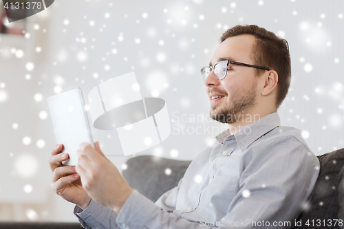 Image of smiling man working with tablet pc at home