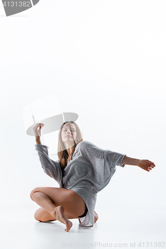 Image of Young beautiful dancer in beige dress dancing on white background