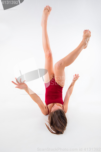 Image of Young beautiful dancer in beige dress dancing on white background