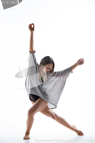 Image of Young beautiful dancer in beige dress dancing on white background