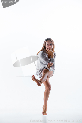 Image of Young beautiful dancer in beige dress dancing on white background