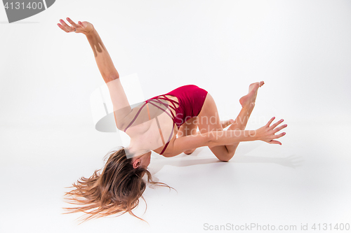 Image of Young beautiful dancer in beige dress dancing on white background