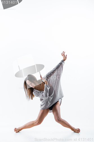 Image of Young beautiful dancer in beige dress dancing on white background