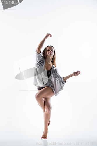 Image of Young beautiful dancer in beige dress dancing on white background