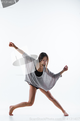 Image of Young beautiful dancer in beige dress dancing on white background