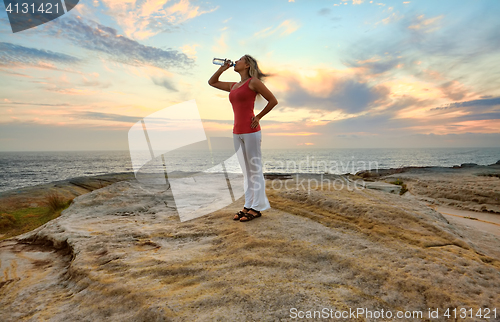 Image of Woman drinking bottled water outdoors