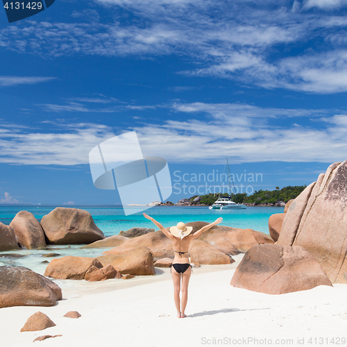 Image of Woman enjoying Anse Lazio picture perfect beach on Praslin Island, Seychelles.