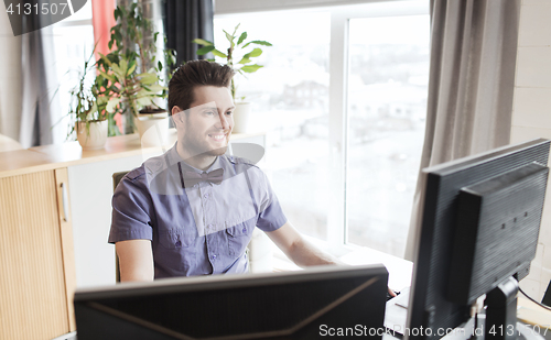 Image of happy creative male office worker with computer