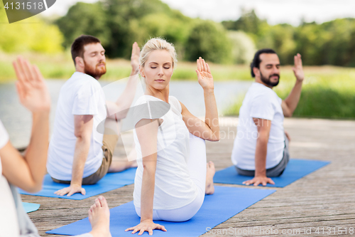 Image of people making yoga in half lord of the fishes pose