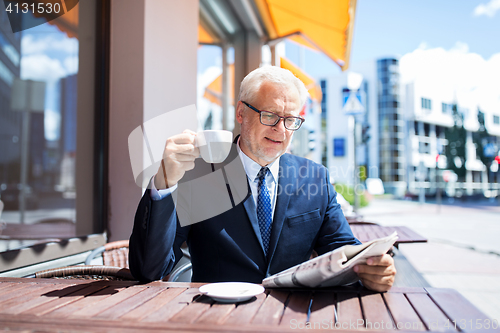 Image of senior businessman with newspaper drinking coffee