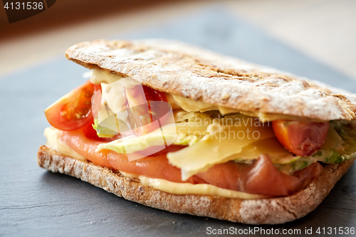 Image of salmon panini sandwich on stone plate