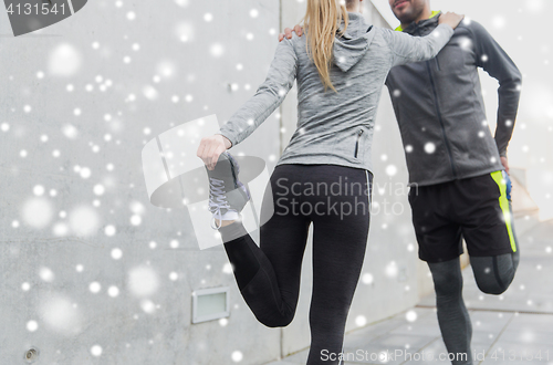 Image of close up of couple stretching legs outdoors