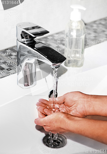 Image of washing hands in modern sink