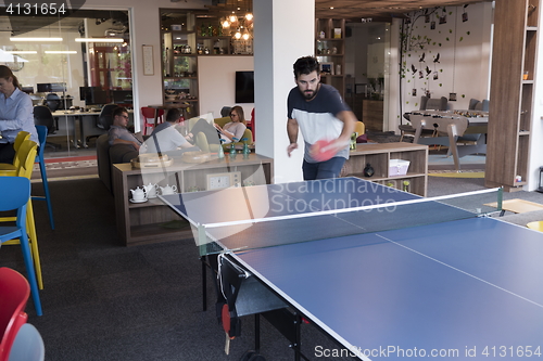 Image of playing ping pong tennis at creative office space