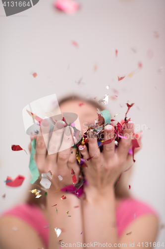 Image of woman blowing confetti in the air