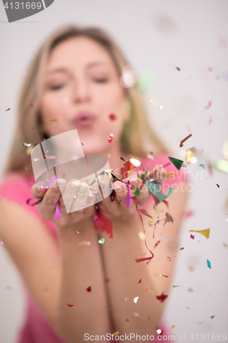 Image of woman blowing confetti in the air