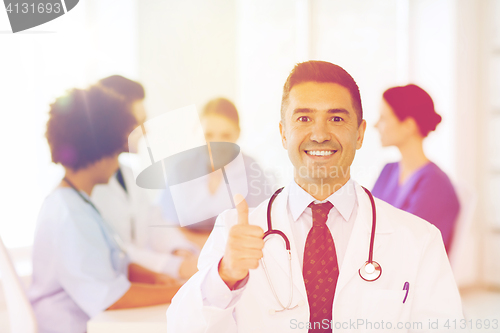 Image of happy doctor over group of medics at hospital