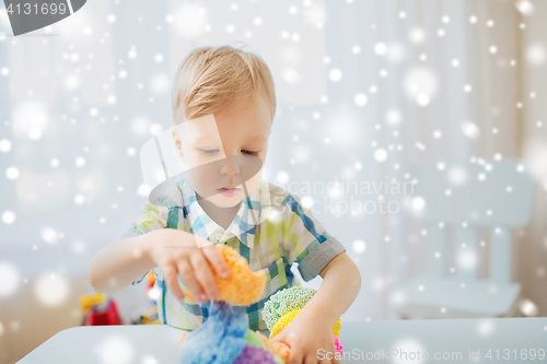 Image of happy little baby boy with ball clay at home