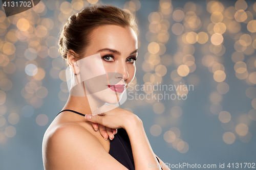 Image of beautiful woman in black over dark background