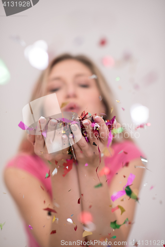 Image of woman blowing confetti in the air