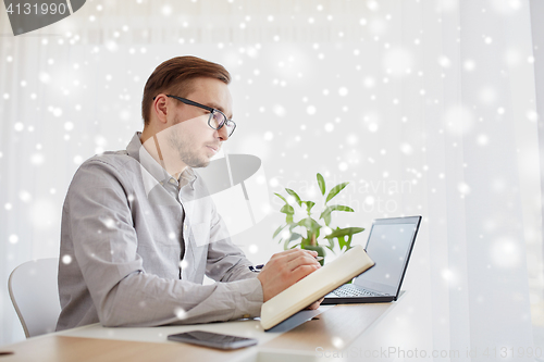 Image of creative man or businessman writing to notebook